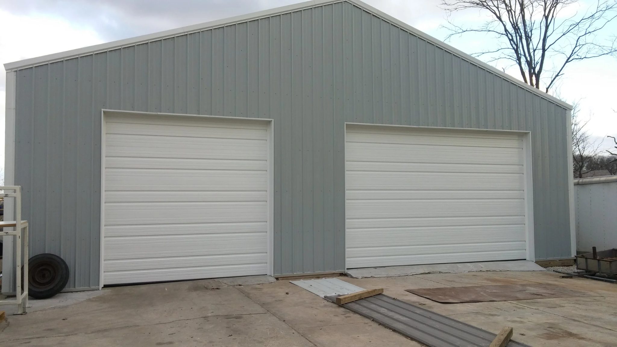 Commercial steel building with two new white sectional garage doors