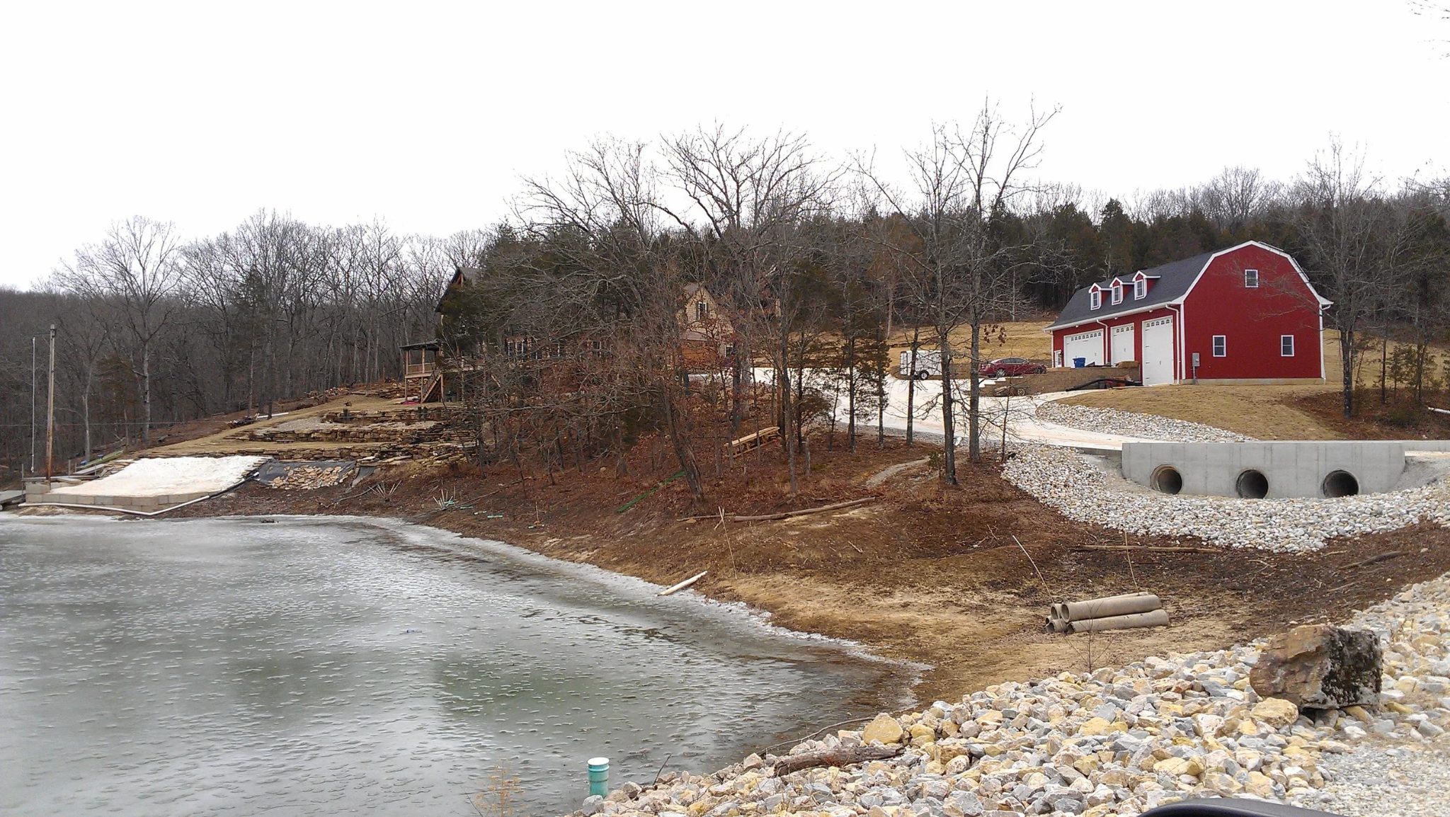 Distant view of a red barn property with newly installed garage doors