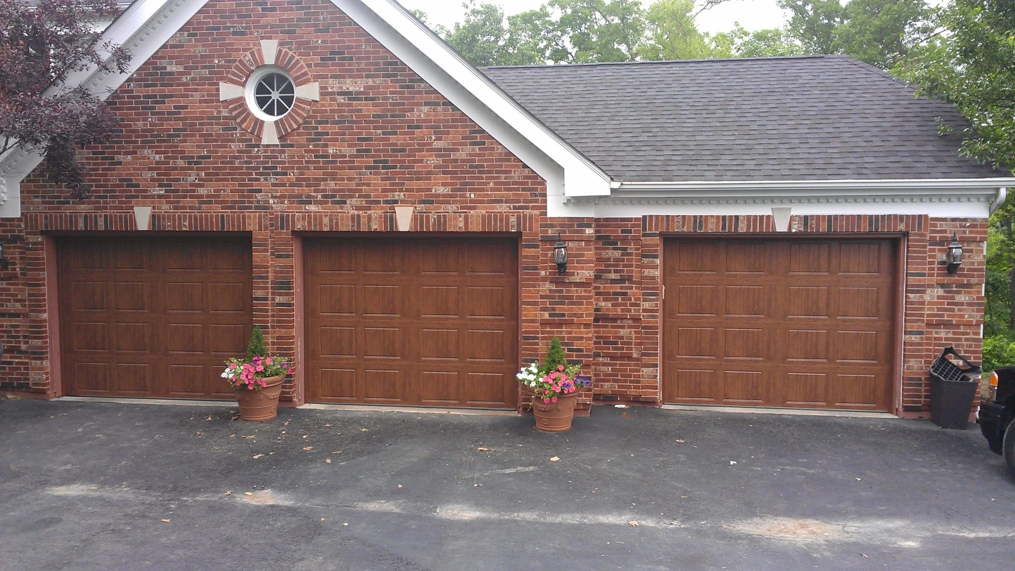 Three-bay brick home with wood-grain residential garage doors